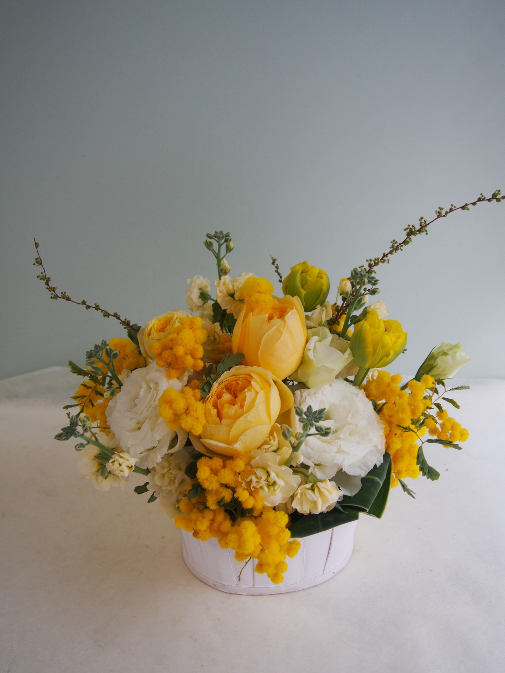 黄色を基調に季節のお花でおつくりしたご退職祝い花