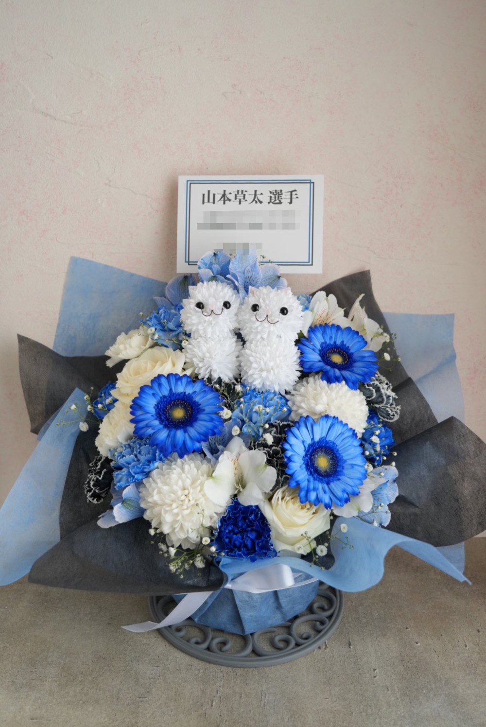 プログラム衣装をモチーフに可愛らしいねこちゃんと一緒におまとめした ご出演祝い花