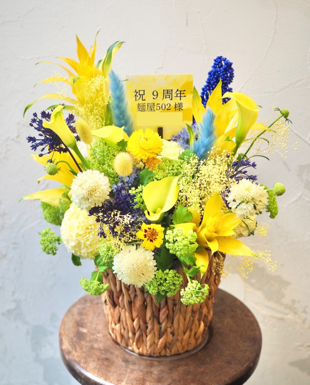 お店の雰囲気に合わせておつりした華やかな周年祝い花