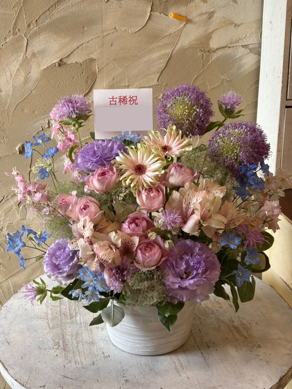 淡いピンクを基調に優しい雰囲気でおつくりした古希祝い花