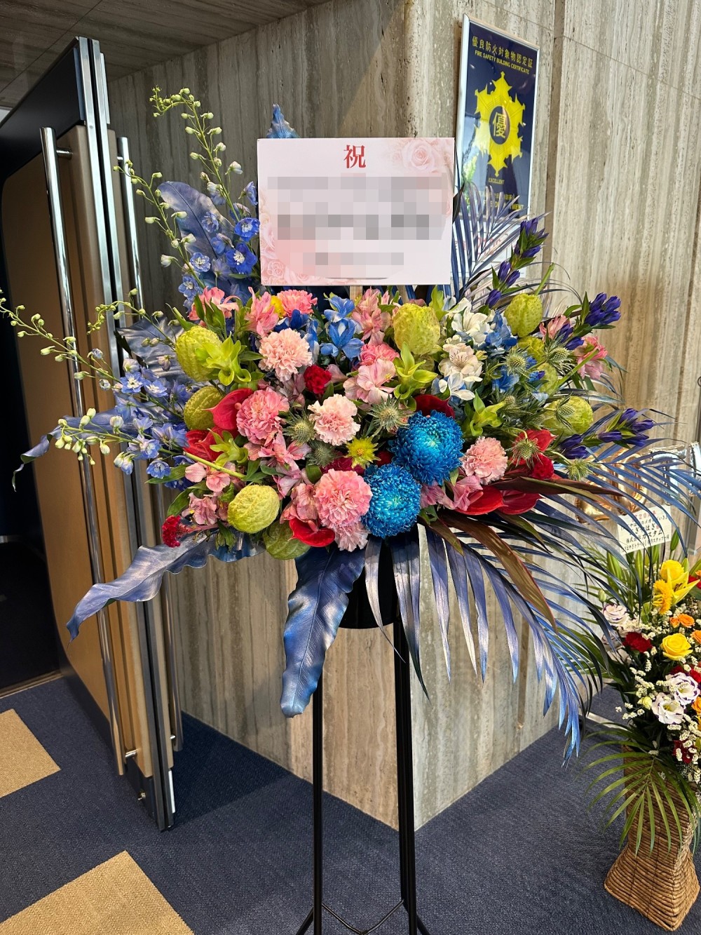 ロゴのカラーでおまとめした周年祝いのフラワースタンド