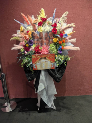 パネルをメインに9色でおまとめした華やかなご出演スタンド花
