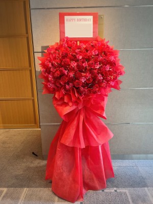 赤を基調に華やかにおつくりしたご出演スタンド花