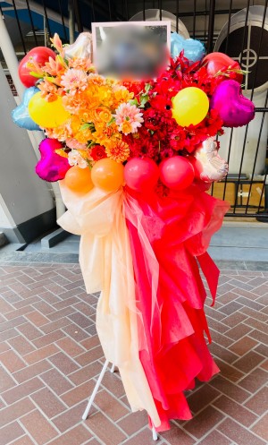 赤とオレンジのツートンカラーでおつくりしたご出演スタンド花