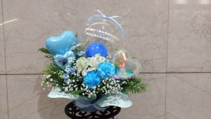 可愛いバルーンを添えてブルーを基調に華やかにおつくりした生花アレンジ